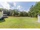 A spacious, green backyard with a shed on a sunny day with partial privacy fence at 7986 Highway 162, Hollywood, SC 29449