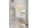 Elegant bathroom featuring a soaking tub and marble flooring beneath a modern chandelier at 7986 Highway 162, Hollywood, SC 29449