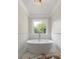 Modern bathroom features a standalone soaking tub, wainscoting and a large window at 7986 Highway 162, Hollywood, SC 29449