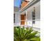 Beautiful front porch with white columns, wood door, a tropical plant and wind chimes in a well-lit, elegant setting at 7986 Highway 162, Hollywood, SC 29449