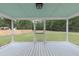 Relaxing screened porch with neutral paint, ceiling fan, and scenic backyard views at 7986 Highway 162, Hollywood, SC 29449