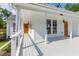 Spacious porch with multiple entry doors, white columns, and an outdoor 'Welcome' mat at 7986 Highway 162, Hollywood, SC 29449