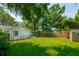 Expansive backyard featuring a lush green lawn, mature trees, a wooden fence and a small storage shed at 8 Tovey Rd, Charleston, SC 29407