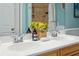Close-up of bathroom double sinks with chrome faucets, complemented by decorative accents and a vase of hydrangeas at 8 Tovey Rd, Charleston, SC 29407