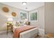 Cozy bedroom features a queen bed, rattan nightstands, and woven wall decor for a tranquil retreat at 8 Tovey Rd, Charleston, SC 29407