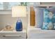 Close-up of the bedside table with a blue lamp and decorative accents near a bed with blue pillows at 8 Tovey Rd, Charleston, SC 29407