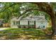 Charming single story home featuring a freshly painted exterior, mature trees, and a well manicured lawn at 8 Tovey Rd, Charleston, SC 29407