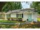Charming single-story home featuring a light blue front door, white exterior, and neatly trimmed landscaping at 8 Tovey Rd, Charleston, SC 29407