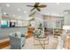 Inviting living room featuring hardwood floors, a ceiling fan, and an open layout into kitchen and dining areas at 8 Tovey Rd, Charleston, SC 29407