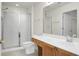 Bathroom with glass-enclosed shower, long vanity with white countertop, wood cabinets, and large mirror at 8800 Dorchester Rd # 2004, North Charleston, SC 29420