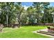 A spacious backyard with lush lawn, a fire pit and wood fence for privacy at 914 Dill Ave, Charleston, SC 29412
