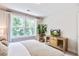 Light-filled bedroom with a large window, stylish furnishings, and a wood cabinet with TV at 914 Dill Ave, Charleston, SC 29412