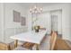 Bright dining room with white table, seating for six, modern chandelier, and view to the stairwell at 1009 Field Sparrow Dr # Cc3-2-6, Ravenel, SC 29470