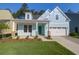 Inviting light blue home with a well-kept lawn and landscaping, featuring a two-car garage at 1009 Field Sparrow Dr # Cc3-2-6, Ravenel, SC 29470