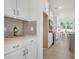 Modern white kitchen with stainless appliances, tile backsplash, and views to the dining room and backyard at 1009 Field Sparrow Dr # Cc3-2-6, Ravenel, SC 29470