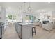 Open-concept living space with kitchen island, stainless appliances, dining area, and comfortable living room furniture at 1009 Field Sparrow Dr # Cc3-2-6, Ravenel, SC 29470