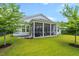 Well-maintained backyard featuring a screened patio, green lawn, and mature trees at 105 Philips Park St, Summerville, SC 29486