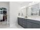 Modern bathroom featuring double vanity, sleek gray cabinetry, and access to a custom-designed walk-in closet at 105 Philips Park St, Summerville, SC 29486