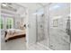 This bathroom features a glass-enclosed shower with elegant marble tiling and a view into the primary bedroom at 105 Philips Park St, Summerville, SC 29486
