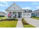 Charming light blue two-story home featuring a welcoming front porch with an American flag at 105 Philips Park St, Summerville, SC 29486