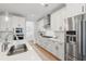 Bright kitchen features white cabinetry, stainless steel appliances, and a spacious quartz countertop at 105 Philips Park St, Summerville, SC 29486