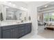 Double vanity with framed mirror in spa-like primary bathroom with marble-look tiled shower at 105 Philips Park St, Summerville, SC 29486