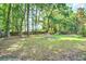 Spacious backyard with lush lawn, mature trees, and a wooded fence line, perfect for outdoor enjoyment at 1052 Yorktown Dr, Charleston, SC 29412