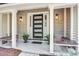 Covered front porch with stylish door, potted plants, and classic lanterns gives a warm welcome at 1052 Yorktown Dr, Charleston, SC 29412