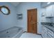 Bathroom features a soaking tub, wood door, and vanity with granite countertop at 107 Joes Ln, Summerville, SC 29486
