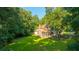 Exterior view of a home with a screened porch and chimney surrounded by trees in a lush green backyard at 107 Joes Ln, Summerville, SC 29486