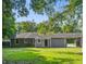 View of the backyard featuring a grassy lawn, mature trees and a rear view of the home at 1112 Yeamans Hall Rd, Hanahan, SC 29410
