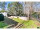 Back yard featuring garden beds, mature trees, an outbuilding, and a black iron fence at 112 Riviera Dr, Summerville, SC 29483