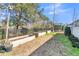 Back yard featuring garden beds, mature trees, and a black iron fence at 112 Riviera Dr, Summerville, SC 29483