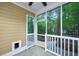 Screened porch with ceiling fan, white railings, and a view of the wooded backyard at 114 Grand Palm Ln, Summerville, SC 29485