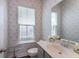 Well-lit half bathroom with a modern vanity, decorative wallpaper, and ample natural light at 120 E Respite Ln, Summerville, SC 29483