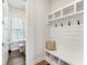 Functional mudroom with built-in shelving, seating, hooks, and nearby half bathroom at 120 E Respite Ln, Summerville, SC 29483