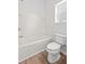 Bright white bathroom with a tub, toilet, and window, featuring simple and clean design at 1302 Paint Horse Ct, Mount Pleasant, SC 29429