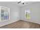 Bright bedroom with wood-look flooring, a ceiling fan, and two large windows for natural light at 1302 Paint Horse Ct, Mount Pleasant, SC 29429