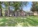 View of backyard featuring swing set, mature trees, and brick exterior at 131 Wedgewood Cir, Goose Creek, SC 29445
