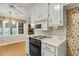A functional kitchen with white cabinetry, an electric stove, and a view of the breakfast nook at 131 Wedgewood Cir, Goose Creek, SC 29445