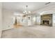 Open-concept living room featuring a brick fireplace, multiple windows, and worn carpeting at 131 Wedgewood Cir, Goose Creek, SC 29445