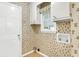 Functional mudroom with a window, white cabinets, and wallpaper at 131 Wedgewood Cir, Goose Creek, SC 29445