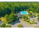 An aerial view showing a community pool surrounded by trees, green spaces and nearby parking at 135 Gaslight Blvd, Summerville, SC 29483