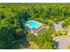 An aerial view of a bright blue community pool surrounded by lush trees at 135 Gaslight Blvd, Summerville, SC 29483