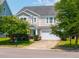 Charming two-story home with a well-maintained lawn, mature trees, and attached two-car garage at 135 Gaslight Blvd, Summerville, SC 29483