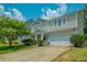 Inviting two-story home featuring manicured lawn, blue sky, and a convenient two-car garage at 135 Gaslight Blvd, Summerville, SC 29483