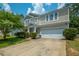Inviting two-story home featuring manicured lawn, blue sky, and a convenient two-car garage at 135 Gaslight Blvd, Summerville, SC 29483