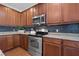 Updated kitchen with stainless steel appliances, granite countertops, and warm wood cabinetry at 135 Gaslight Blvd, Summerville, SC 29483