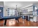 The stylish living area boasts a pool table, hardwood floors, modern lighting, and charming decor, ready for games at 135 Gaslight Blvd, Summerville, SC 29483