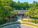 An aerial view of a pool house surrounded by palm trees, featuring a covered entrance and well-maintained landscaping at 135 Gaslight Blvd, Summerville, SC 29483